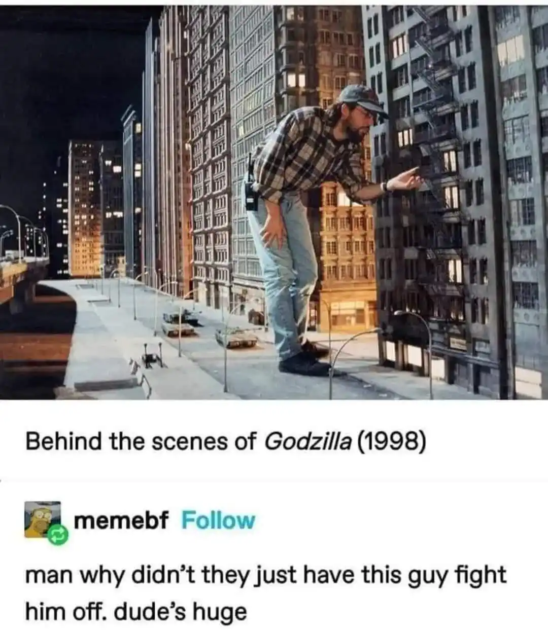 A man in a plaid shirt and cap stands on a miniature city street set, gesturing toward a tiny building model. The caption…