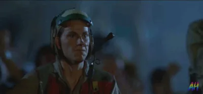 A man in a military-style helmet and headset is shown in a sequence of frames, initially looking forward, then raising his…