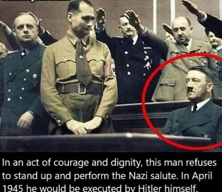 A historical photograph shows several men in Nazi uniforms, most raising their right arms in a salute. One man in the center…