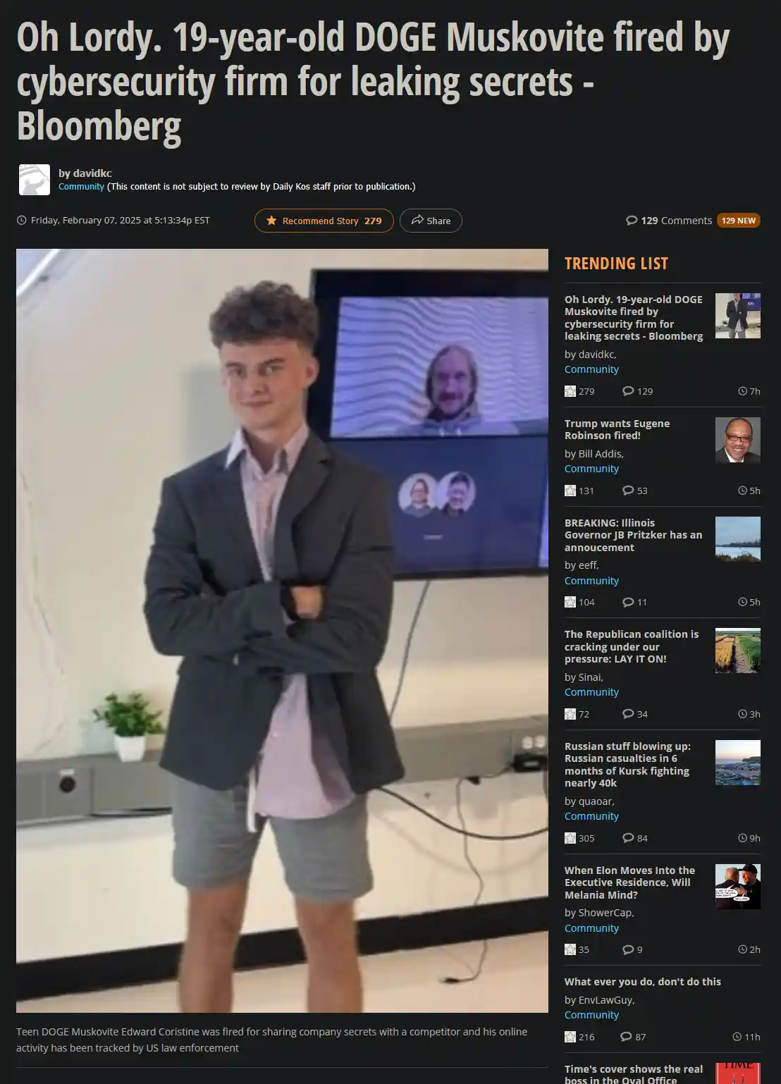 A young man in a blazer and shorts stands with arms crossed in front of a screen showing a video call with a bearded man…