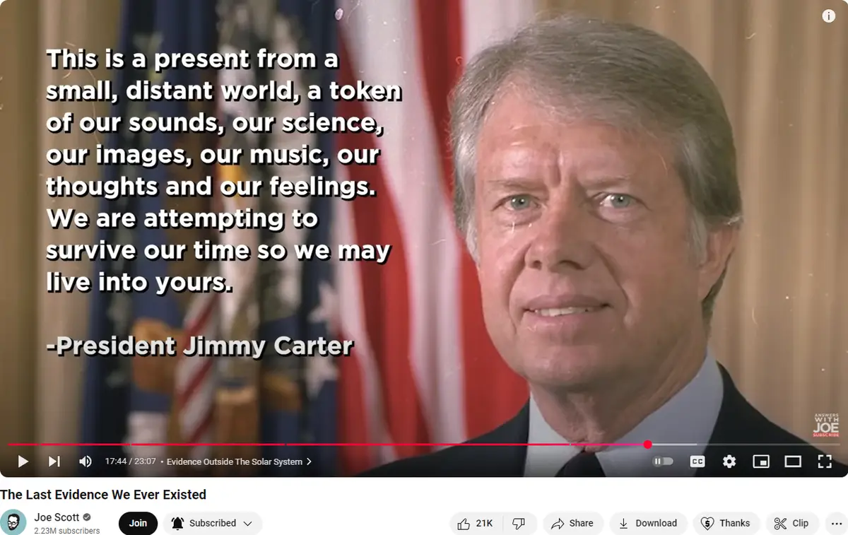 A still image from a video shows President Jimmy Carter smiling while standing in front of American flags. Overlaid white…