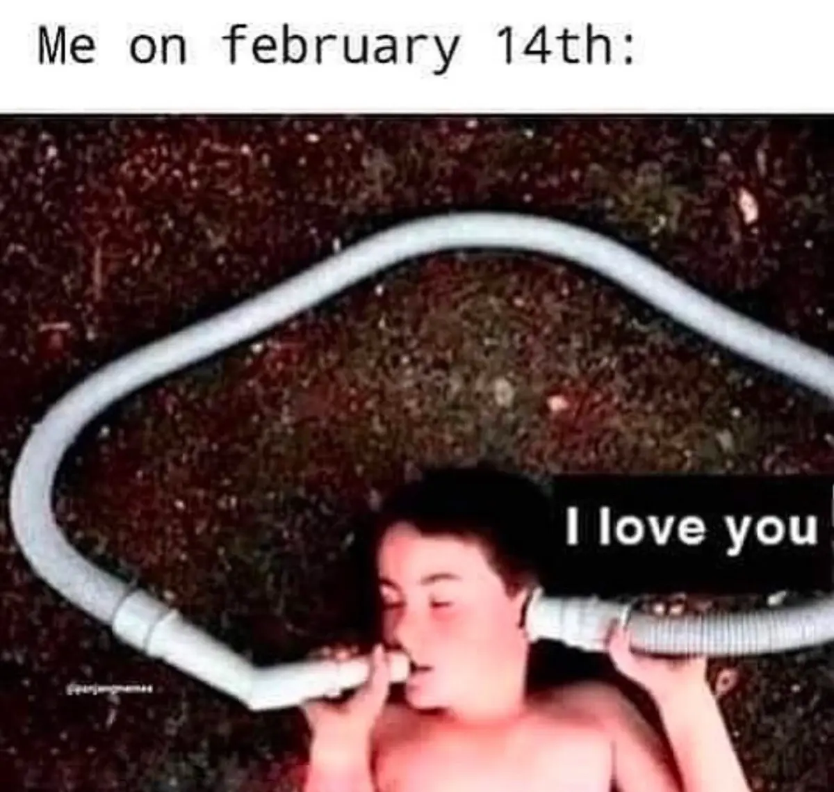 A shirtless young person lies on dark ground, holding a white flexible hose to their mouth, with the text 'Me on february…