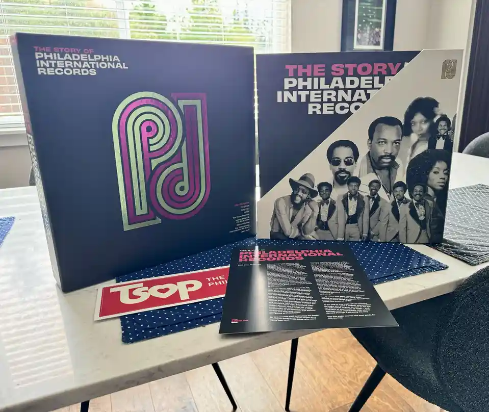 Two large, open vinyl record boxes for 'The Story of Philadelphia International Records' sit on a table, revealing a…