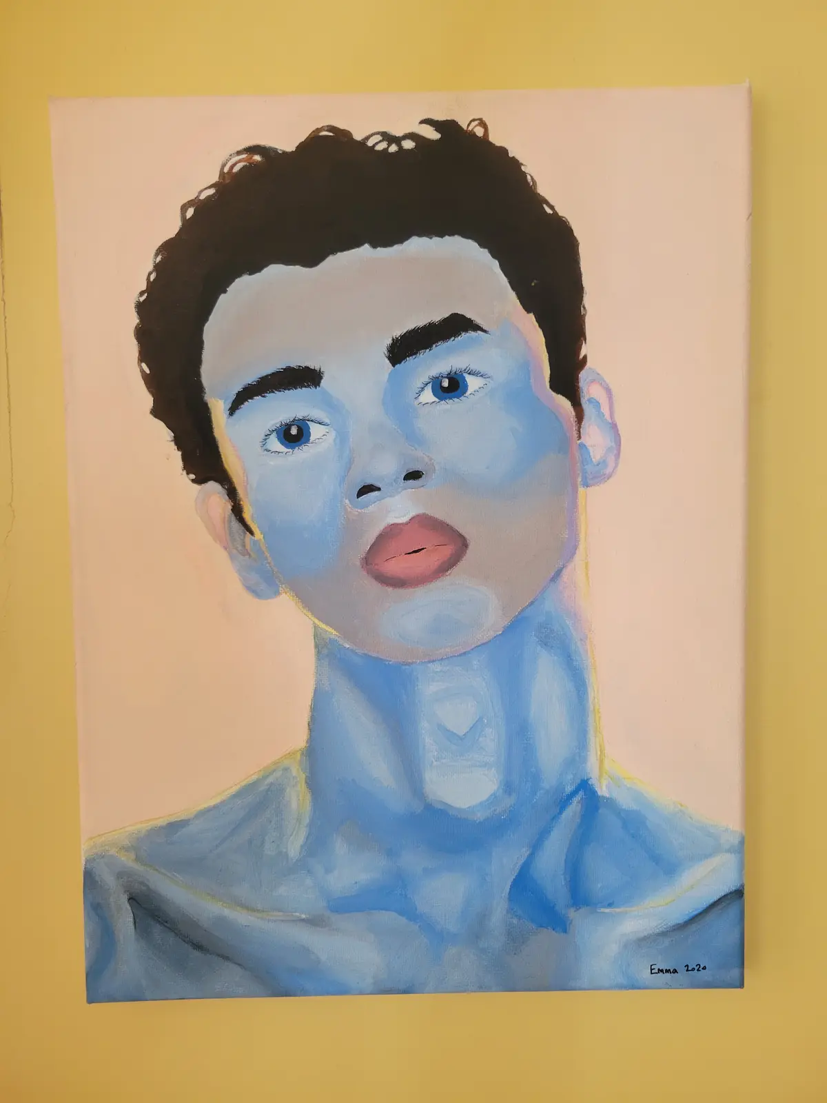 A painted portrait of a young person with blue skin, dark curly hair, and wide eyes, hanging on a yellow wall. The painting…