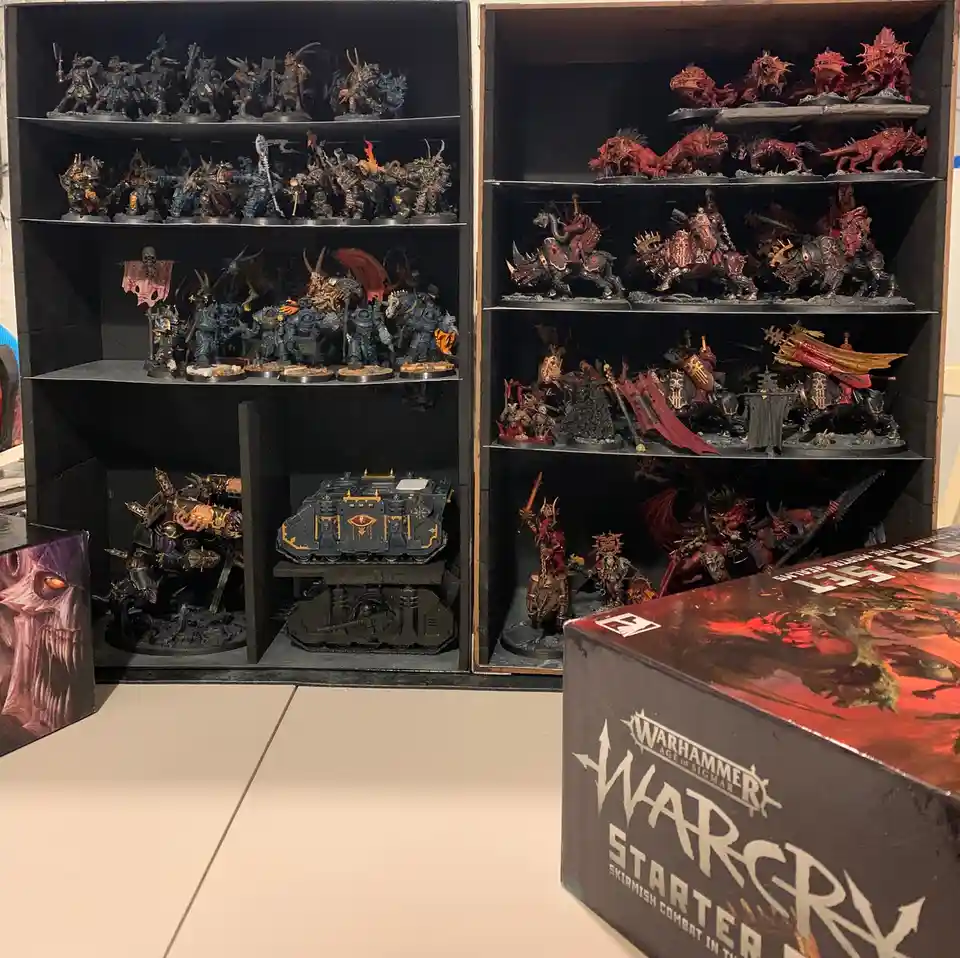 Two large display cases filled with numerous painted miniature figurines from the Warhammer Age of Sigmar universe, with a…