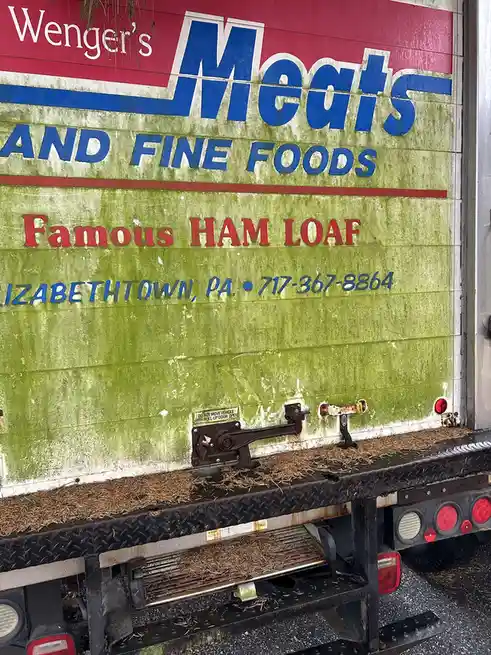 The image shows the back of a delivery truck for 'Wenger's Meats AND FINE FOODS', which advertises 'Famous HAM LOAF' and…