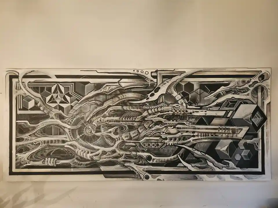 A long, rectangular black-and-white artwork hangs on a beige wall, featuring intricate, abstract, and surreal designs with…