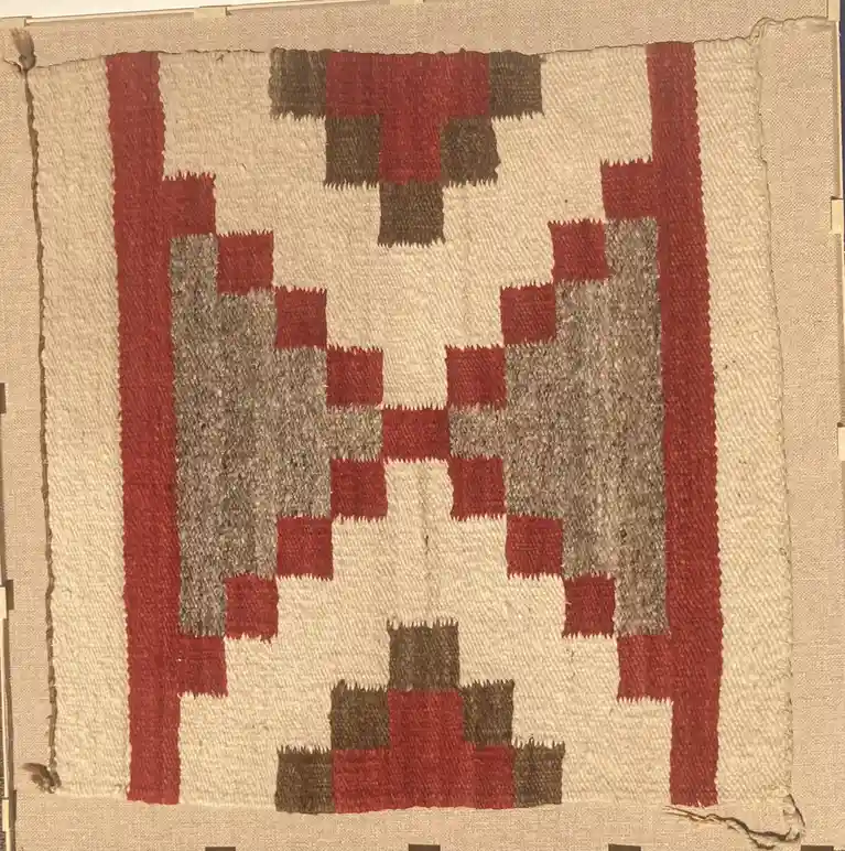 a close-up of a traditional woven textile, likely a southwestern or native american rug, featuring a geometric pattern in…
