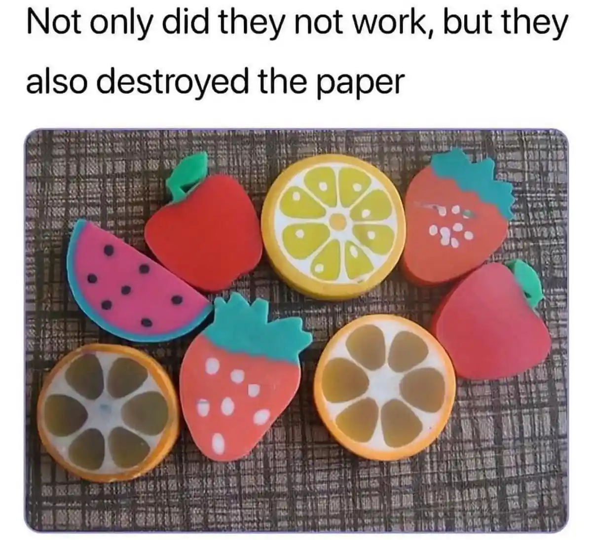 The image shows seven fruit-shaped erasers — including watermelon, apple, strawberry, and lemon slices — arranged on a…