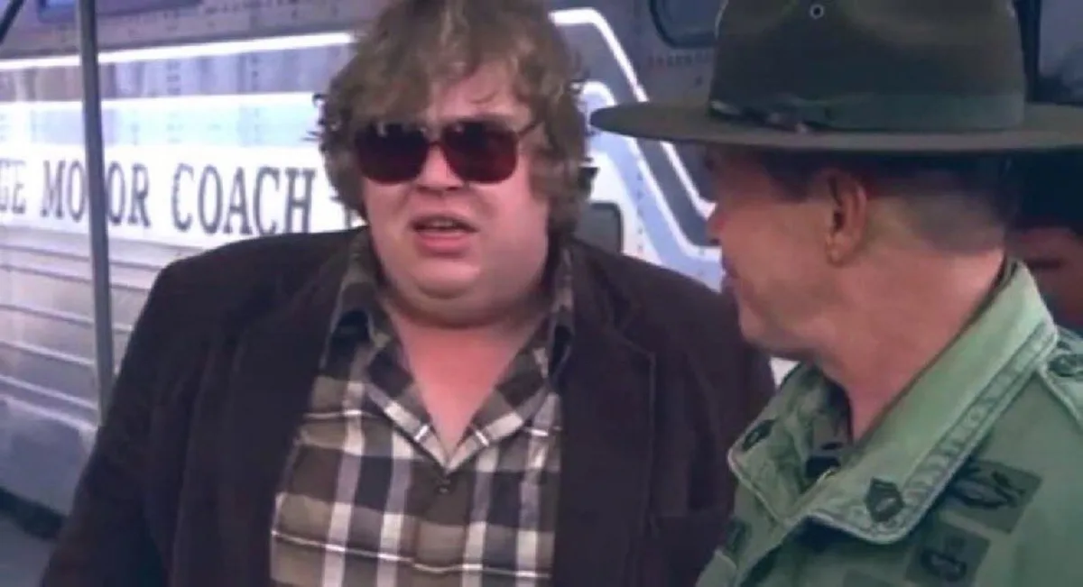a still from the movie 'The Blues Brothers' shows a man in a plaid shirt and sunglasses looking surprised while talking to a…