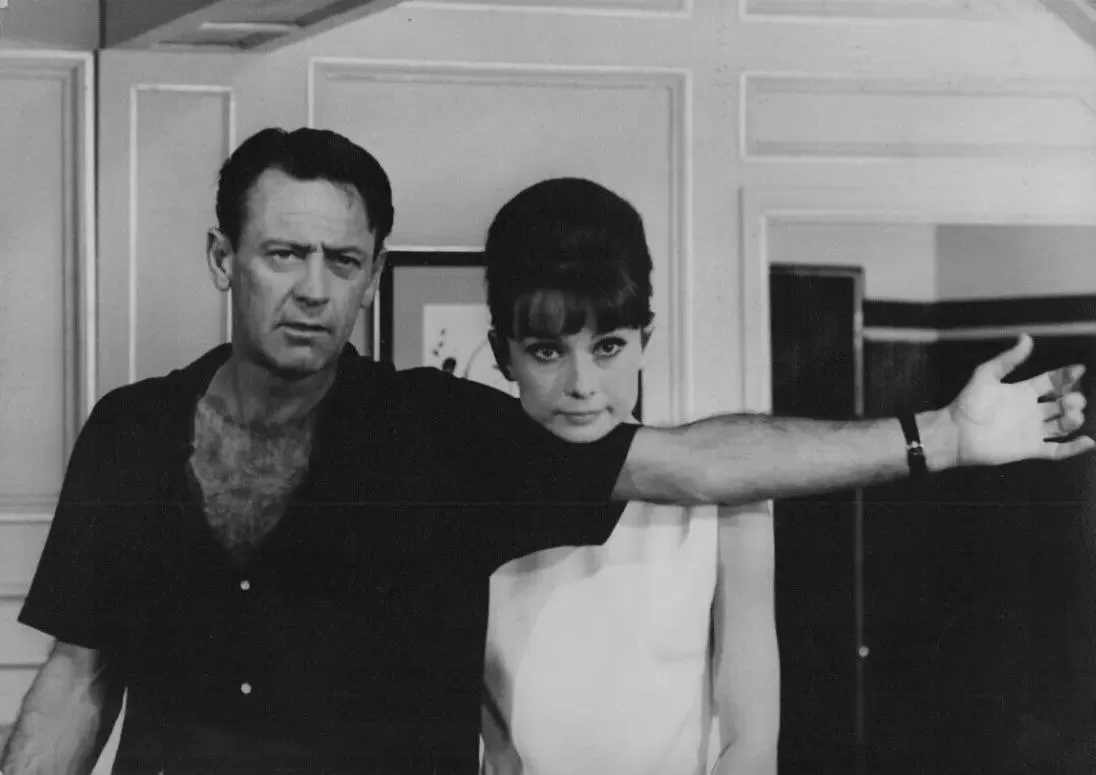 a black-and-white photo of actors Richard Burton and Audrey Hepburn from the 1964 film 'Wait Until Dark,' with Burton's arm…