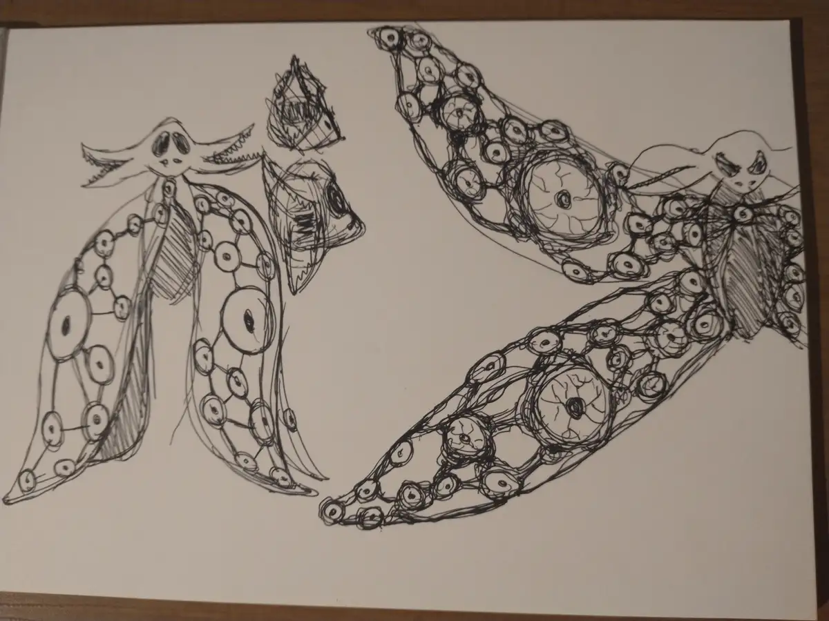 A black-and-white sketch on paper shows two stylized, monstrous creatures made of interconnected eyeballs, with one creature…