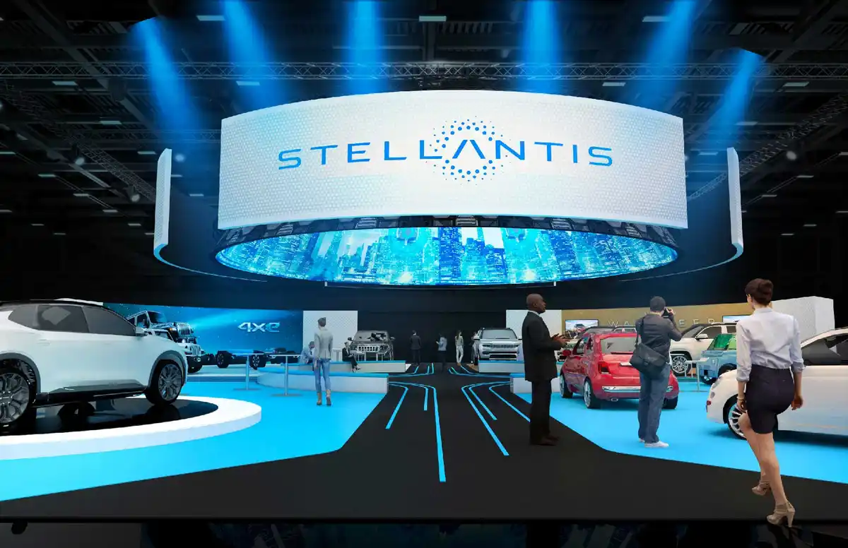 A promotional image of the Stellantis automotive brand's futuristic showroom, featuring a large circular sign with the…