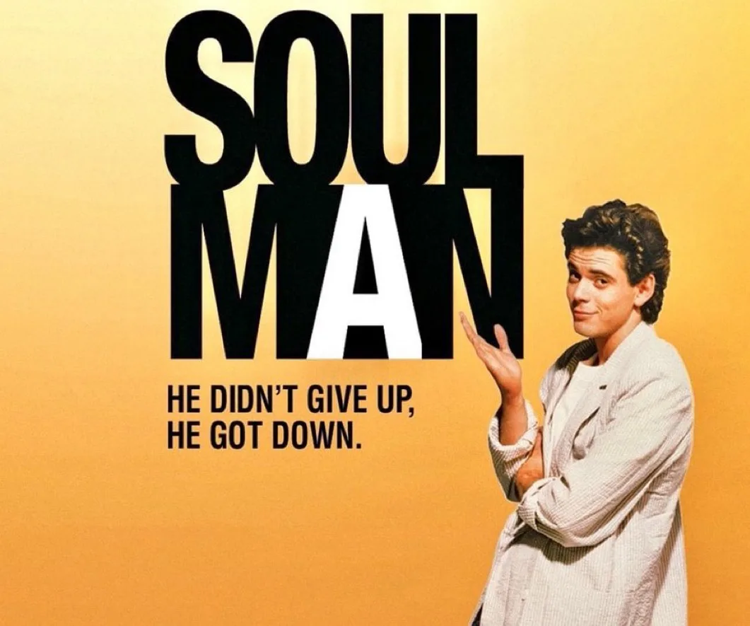 The image is a promotional poster for the 1997 film 'Soul Man,' featuring actor John Stamos in a light-colored jacket…