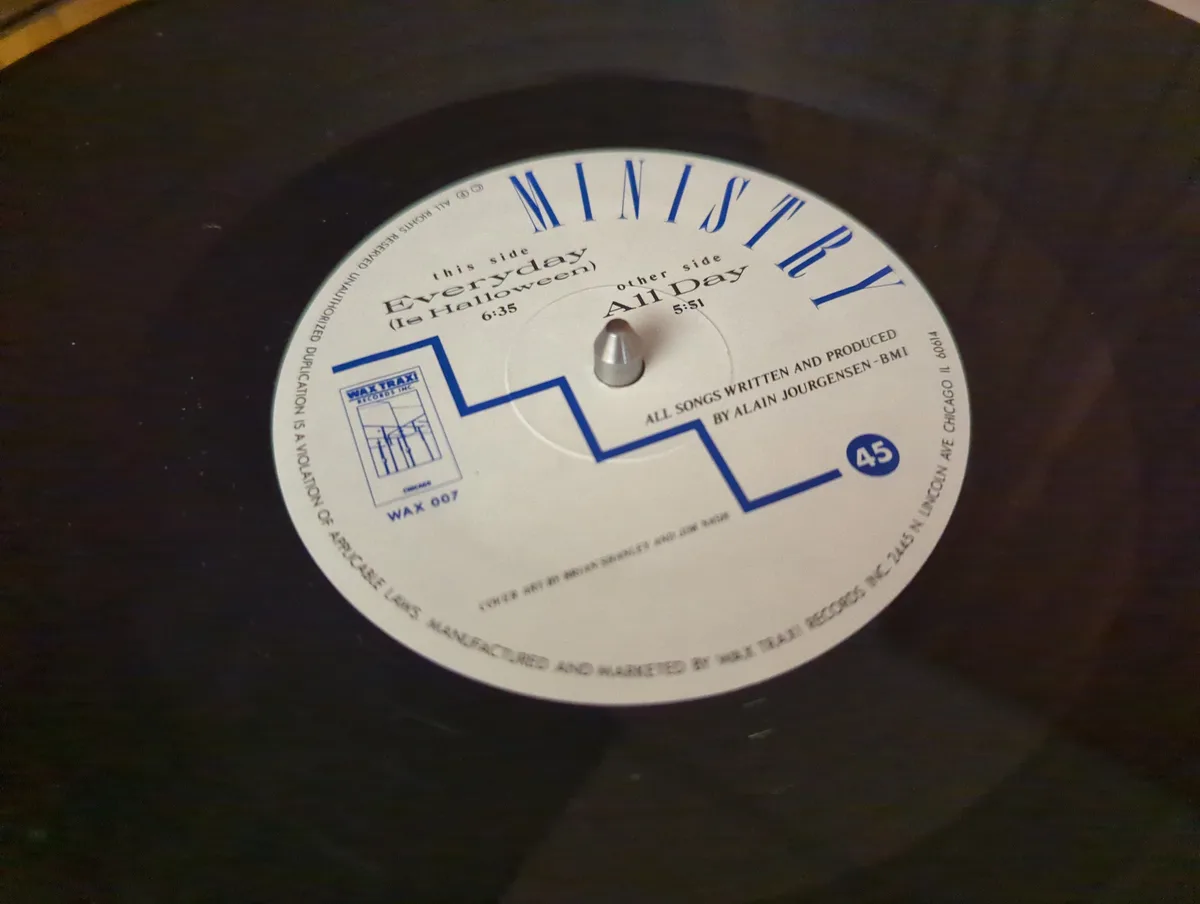 A close-up of a black vinyl record label for the band Ministry, showing the track titles 'Everyday (Le Halloween)' and 'All…