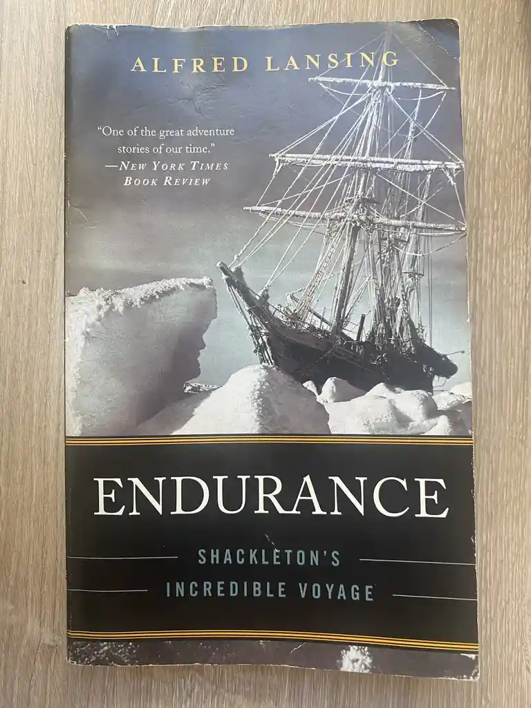 A worn copy of Alfred Lansing's book 'Endurance: Shackleton's Incredible Voyage' shows a ship trapped in ice on its cover…