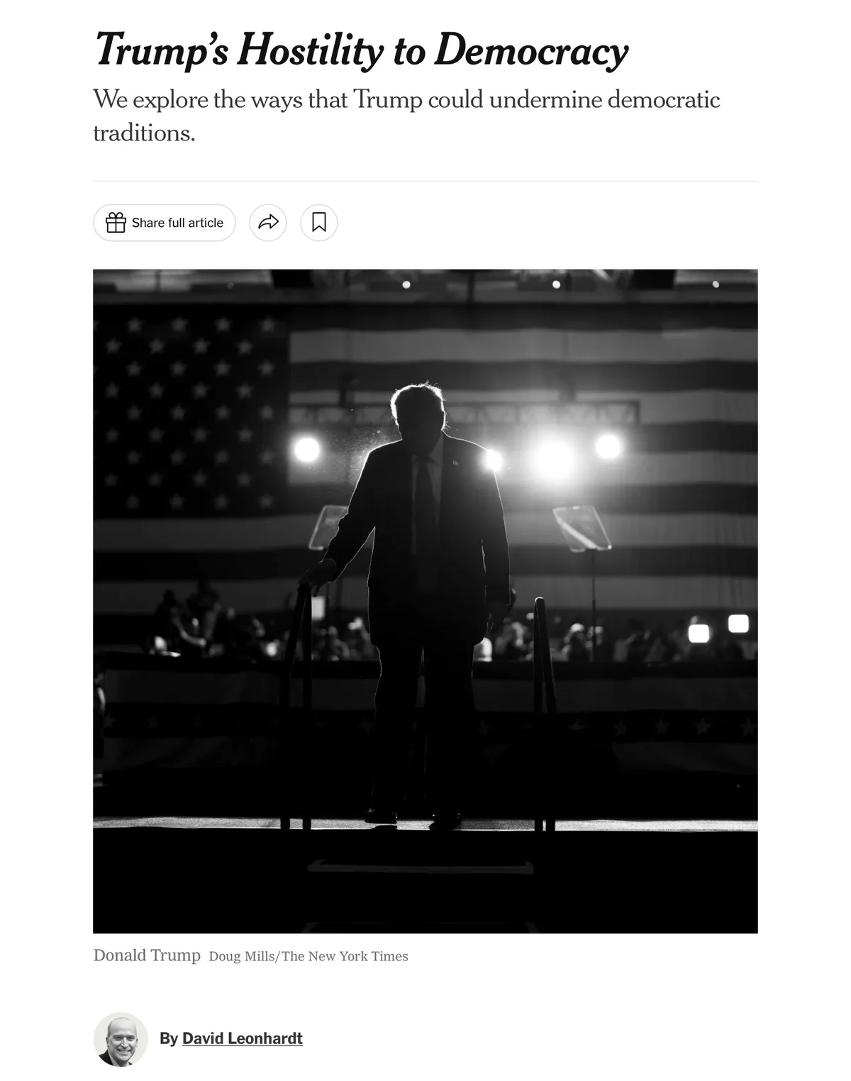 A black and white photo shows the silhouette of Donald Trump walking down a stage with an American flag in the background…