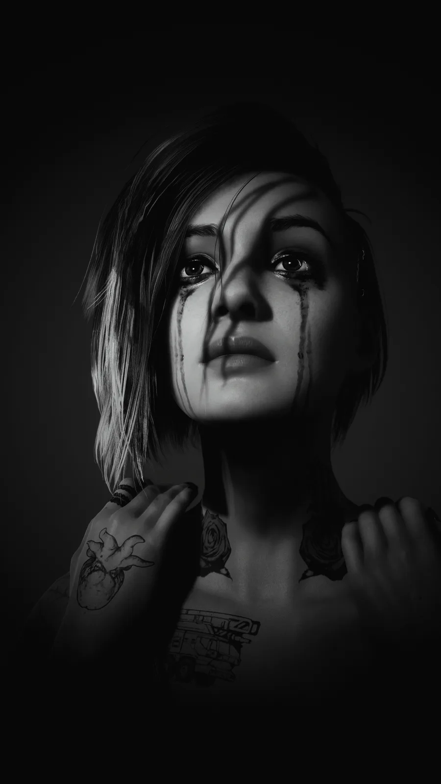 A black-and-white image of a woman with short hair, tears streaming down her face, and multiple tattoos on her neck, chest…
