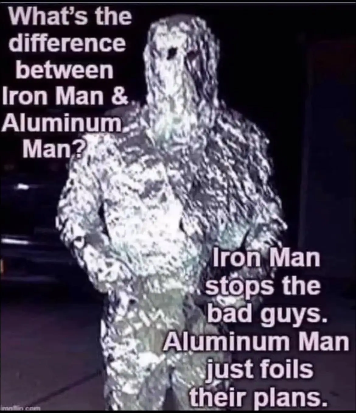 A person is fully wrapped in crinkled aluminum foil, standing in a dark outdoor setting. The image has white text overlaid…