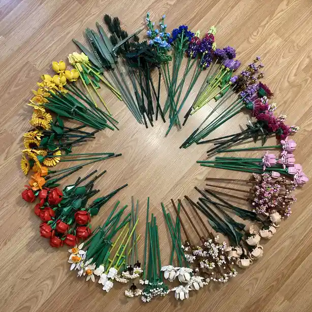 A circular arrangement of various LEGO-built flowers in multiple colors and types, including sunflowers, roses, tulips, and…