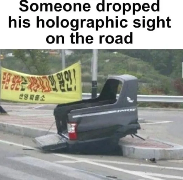 A black pickup truck is parked at an angle on a paved road, its rear end lifted and resting on a concrete curb. The truck's…