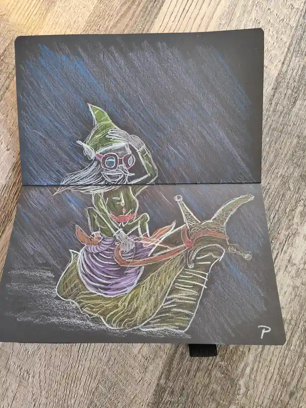 A hand-drawn illustration on dark paper shows a green-skinned, bespectacled character with a pointed hat riding a large…