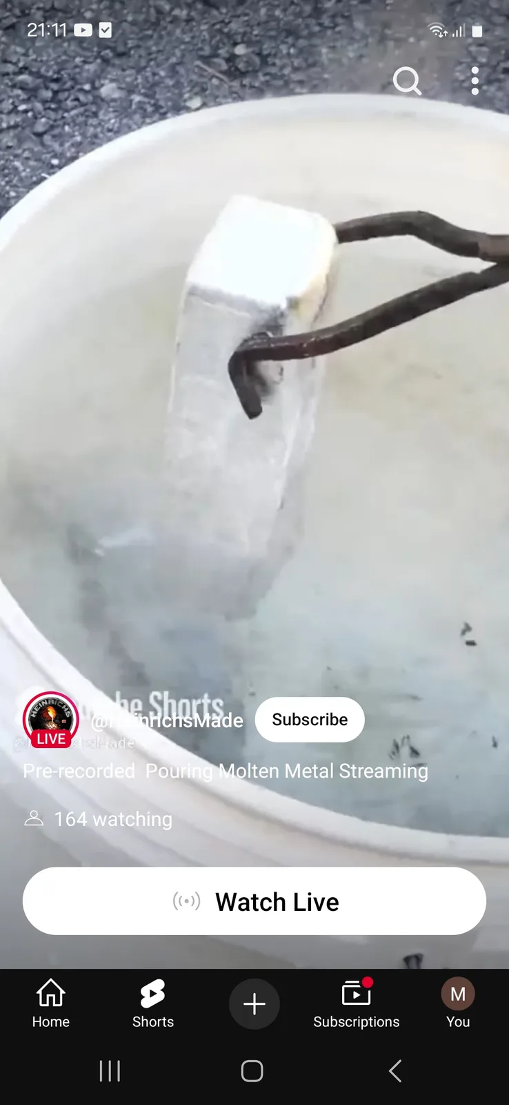 A YouTube Shorts interface shows a white bucket filled with water, where a large, rectangular block of ice is being held by…