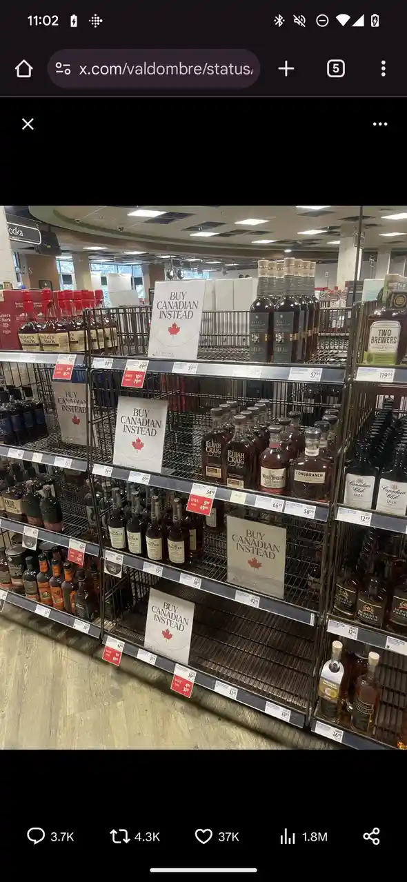 A photo of a liquor store shelf with multiple signs reading 'BUY CANADIAN INSTEAD' featuring a red maple leaf, placed among…