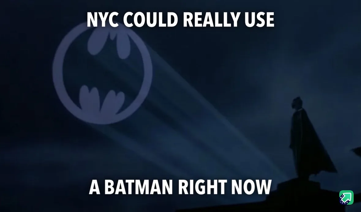 A dark, atmospheric image shows the silhouette of Batman standing on a rooftop at night, with a large, glowing Batman logo…
