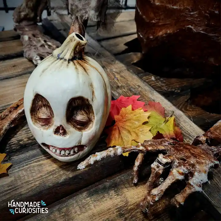 A carved pumpkin with a skull-like face, featuring hollow eyes, a nose, and a toothy grin, rests on a rustic wooden surface…