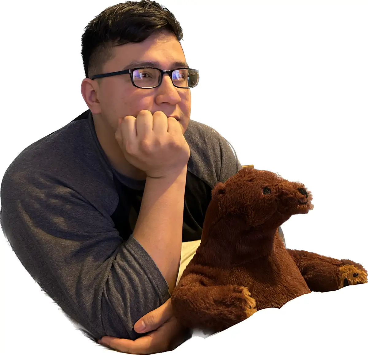 A man with dark hair and glasses, wearing a gray shirt, rests his chin on his hand in a pensive pose. Beside him sits a…