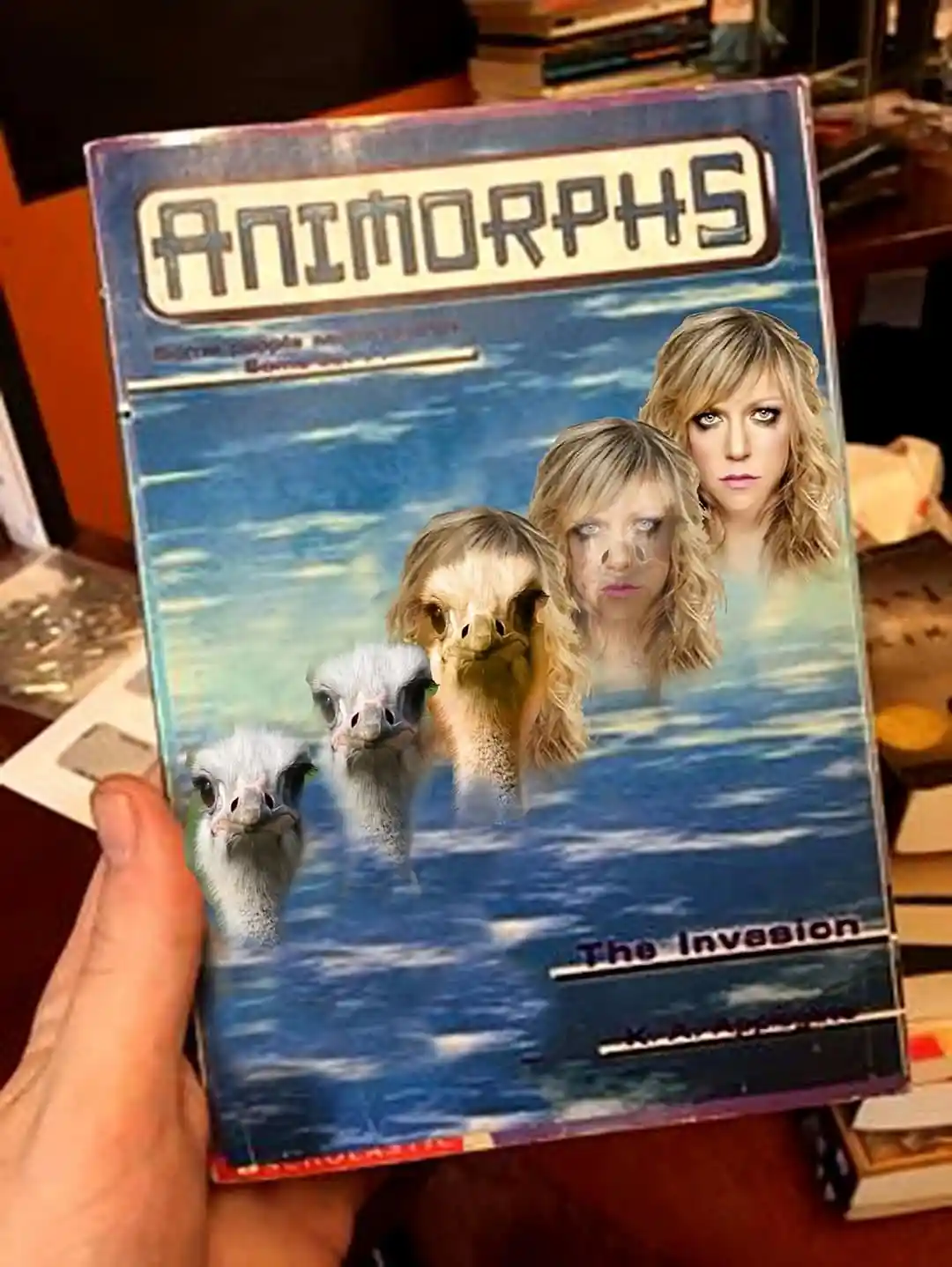A hand holds a book cover for 'Animorphs: The Invasion' by K.A. Applegate, but the original artwork has been replaced with…