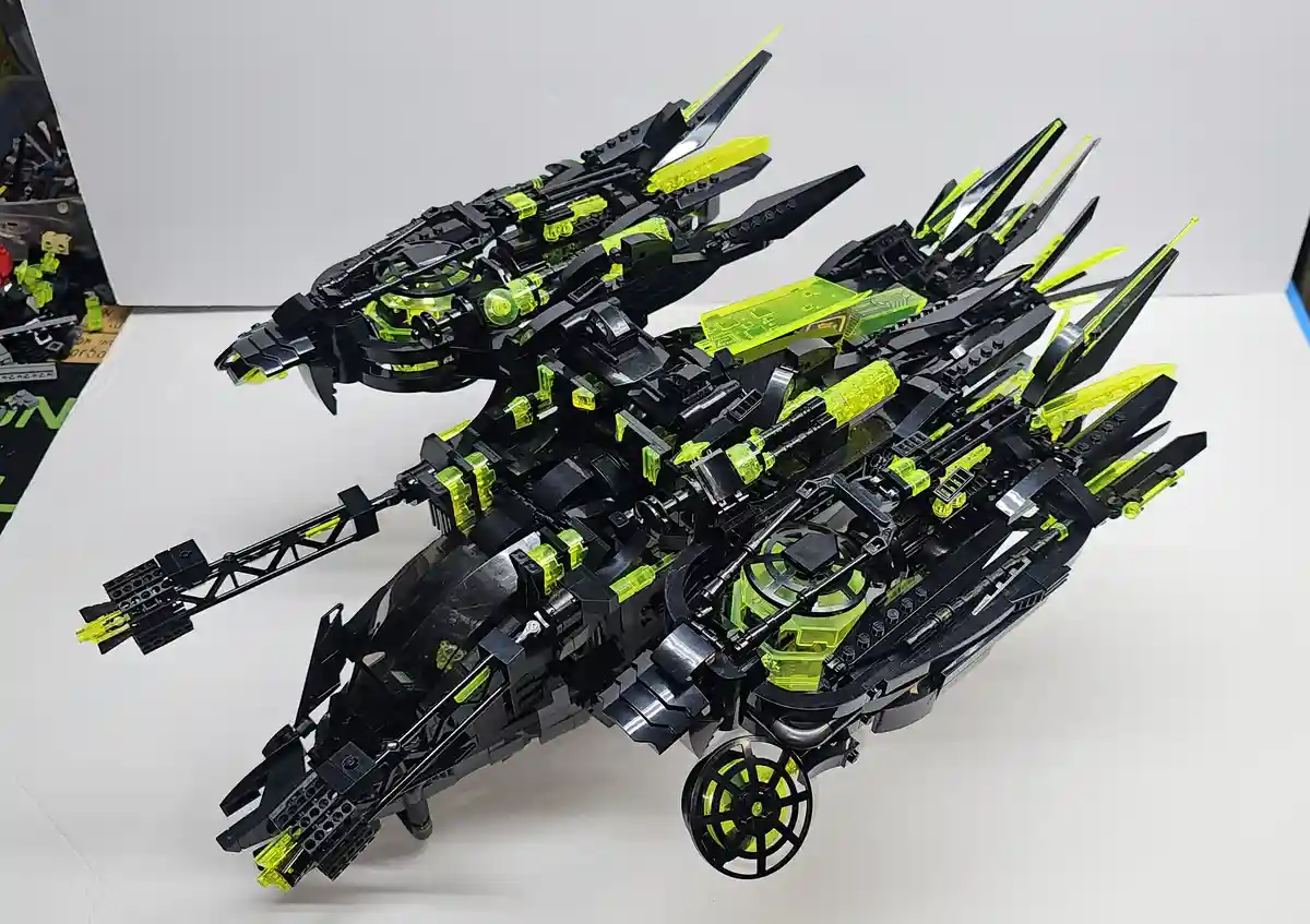 A highly detailed, black and neon green Lego model of Batman's Batmobile, featuring sharp angular designs, multiple…