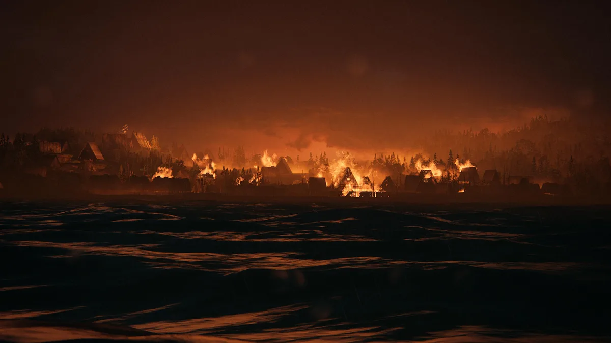 A dramatic, fiery scene shows a village of wooden cabins burning intensely under an orange sky, viewed from across dark…