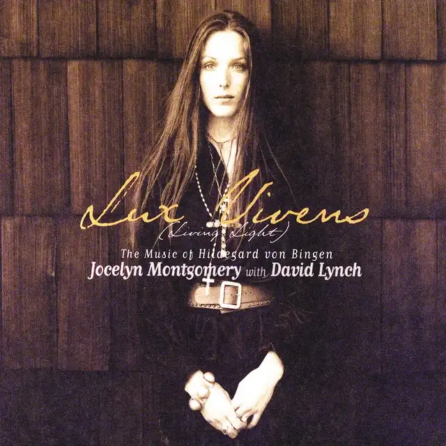 An album cover featuring a woman with long hair and a cross necklace standing against a wooden wall, with overlaid text…