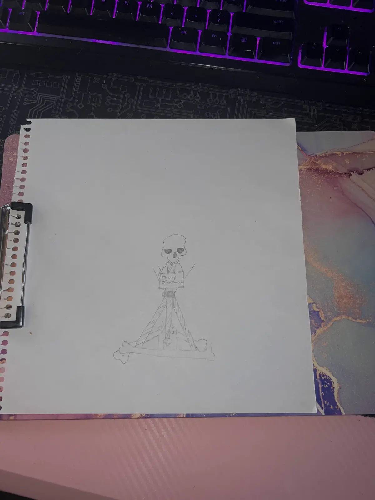 A hand-drawn sketch on a spiral-bound notebook page shows a cartoonish skeleton wearing a hat and holding a sign that reads…