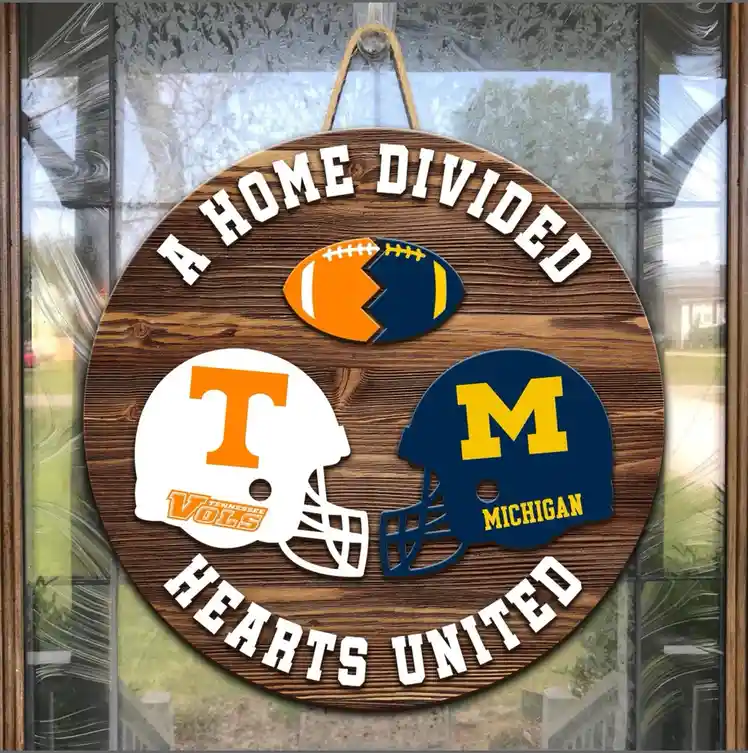 A circular wooden sign hangs on a glass door, featuring the text 'A HOME DIVIDED' at the top and 'HEARTS UNITED' at the…