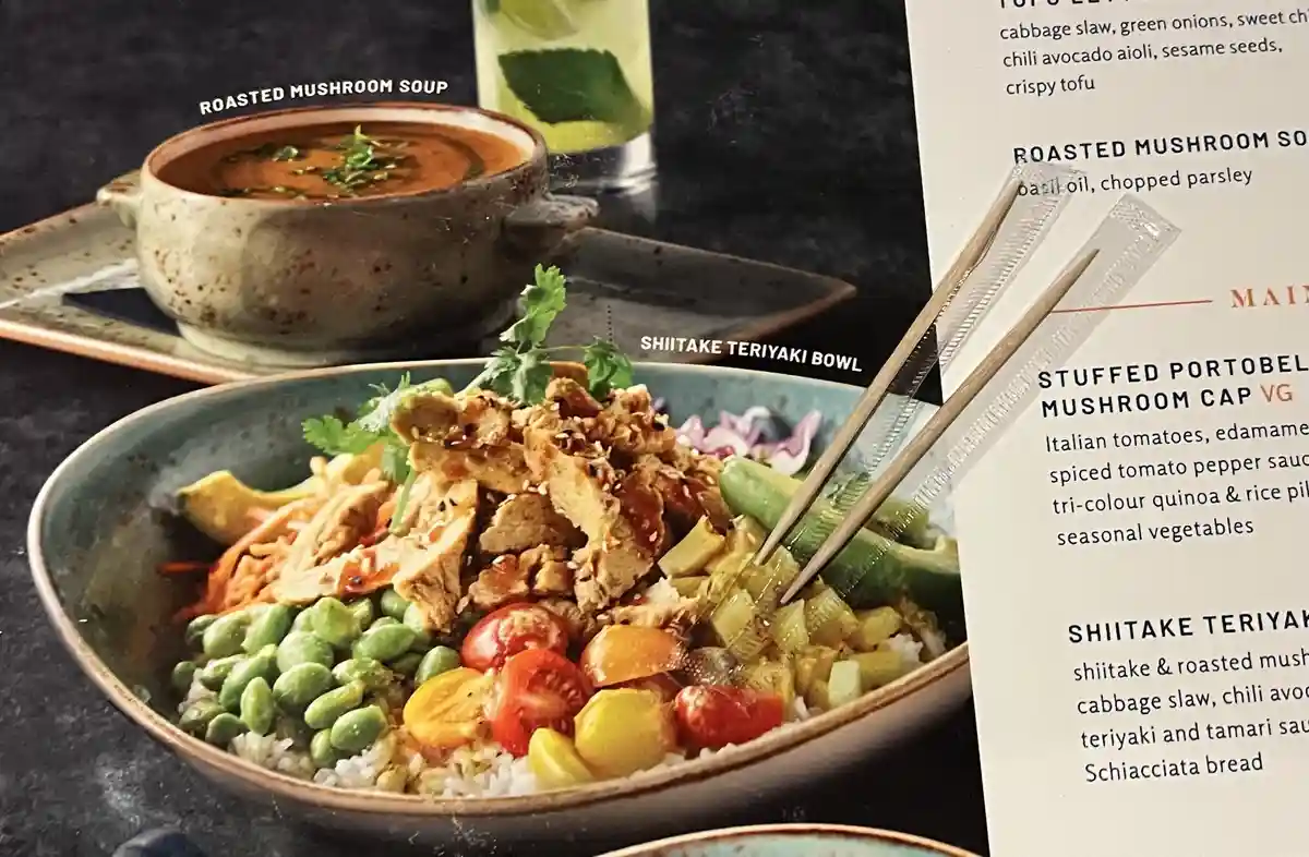 A close-up photo of a restaurant menu featuring a 'Shiitake Teriyaki Bowl' with chopsticks inserted, next to a 'Roasted…