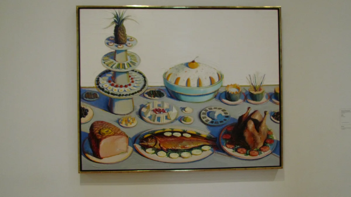 a framed painting depicts a lavish, colorful banquet table with a tiered stand topped by a pineapple, a covered dish…