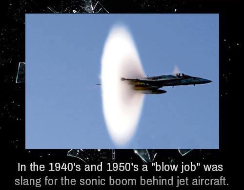 A jet aircraft is shown flying at high speed against a clear blue sky, leaving behind a large, bright white shockwave cone…
