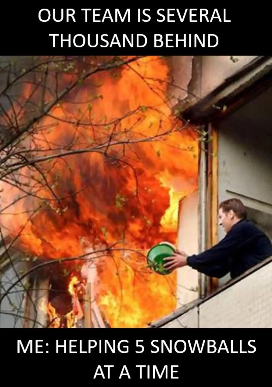 A man leans out of a window holding a green bucket while a large fire rages outside. The top text reads 'OUR TEAM IS SEVERAL…