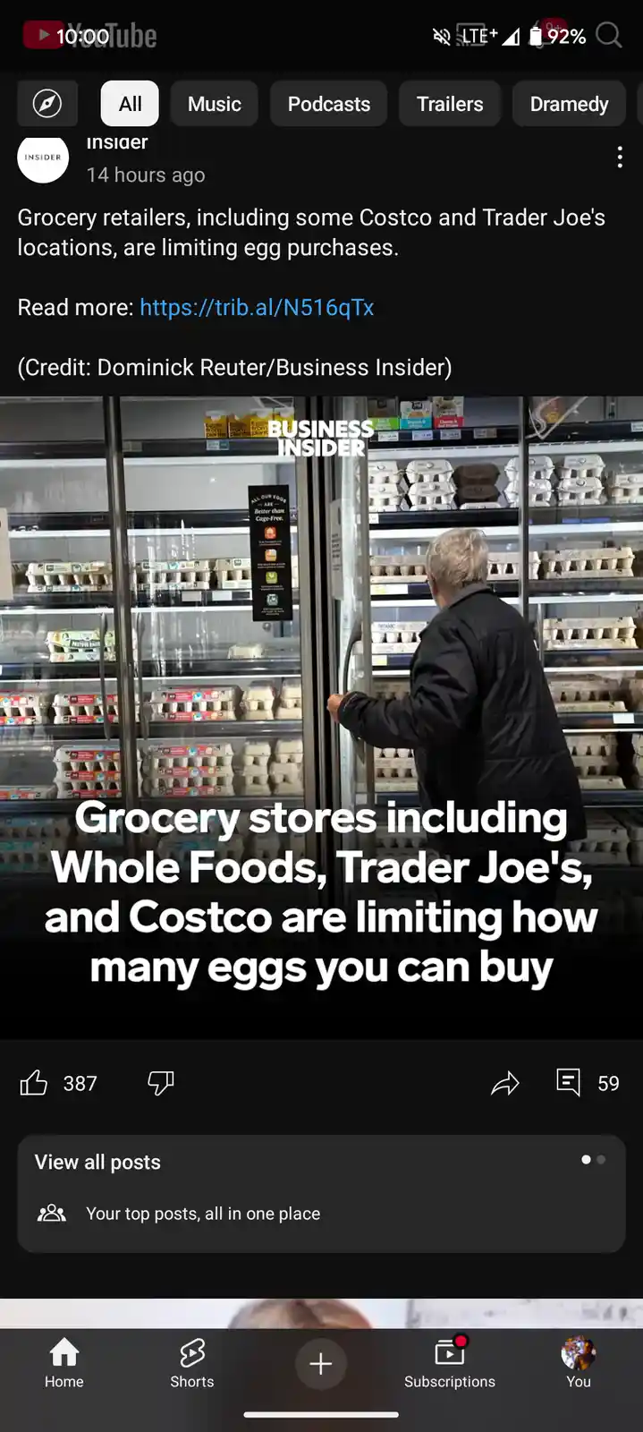 A person in a black jacket stands in front of a refrigerated grocery store aisle filled with egg cartons, looking at the…