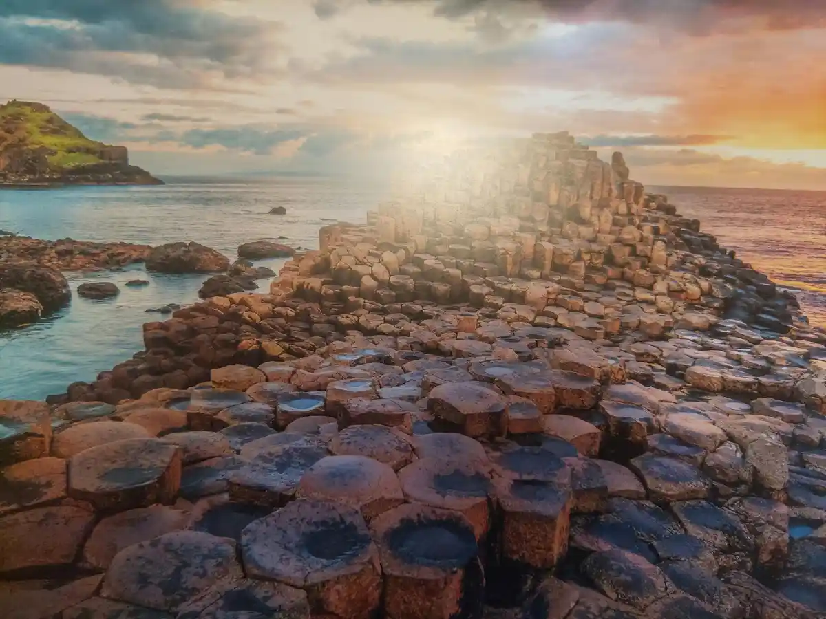 A scenic photo of the Giant's Causeway in Northern Ireland, featuring distinctive hexagonal basalt columns rising from the…