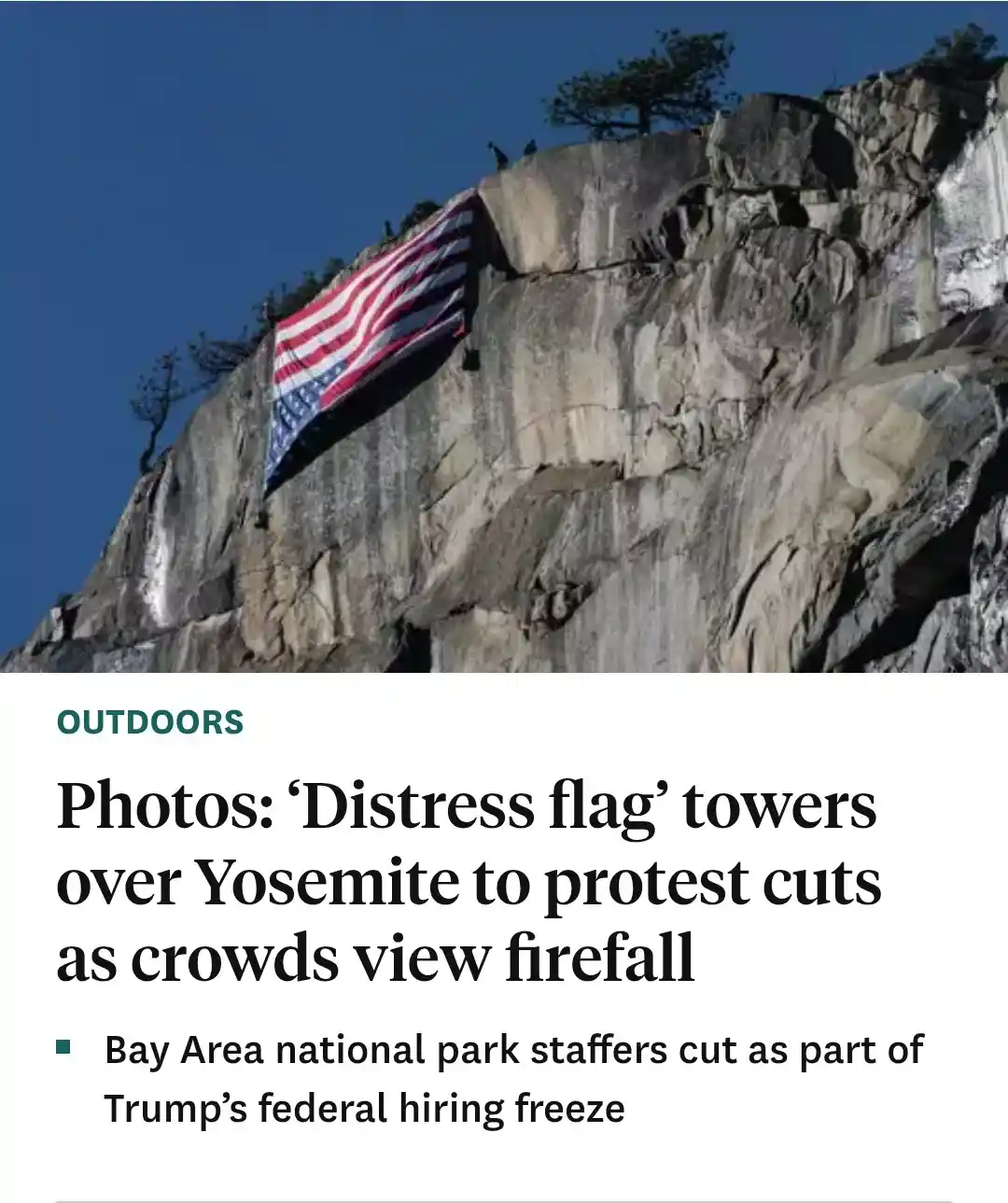 A large American flag is displayed on a steep rock face in Yosemite National Park under a clear blue sky. Below the image is…