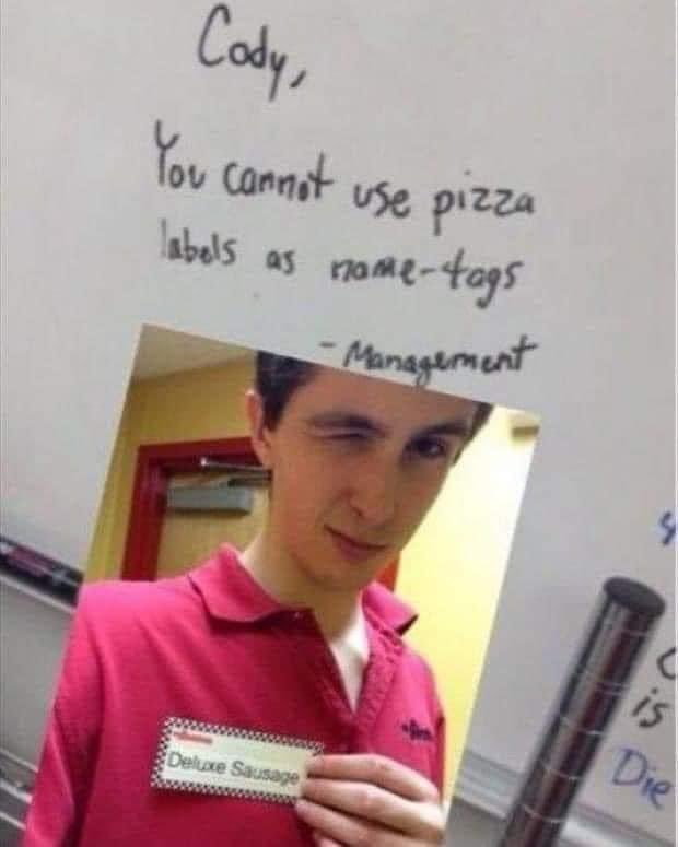 A photo of a young man in a red polo shirt holding a pizza label that reads 'Deluxe Sausage' as a name tag, overlaid with…