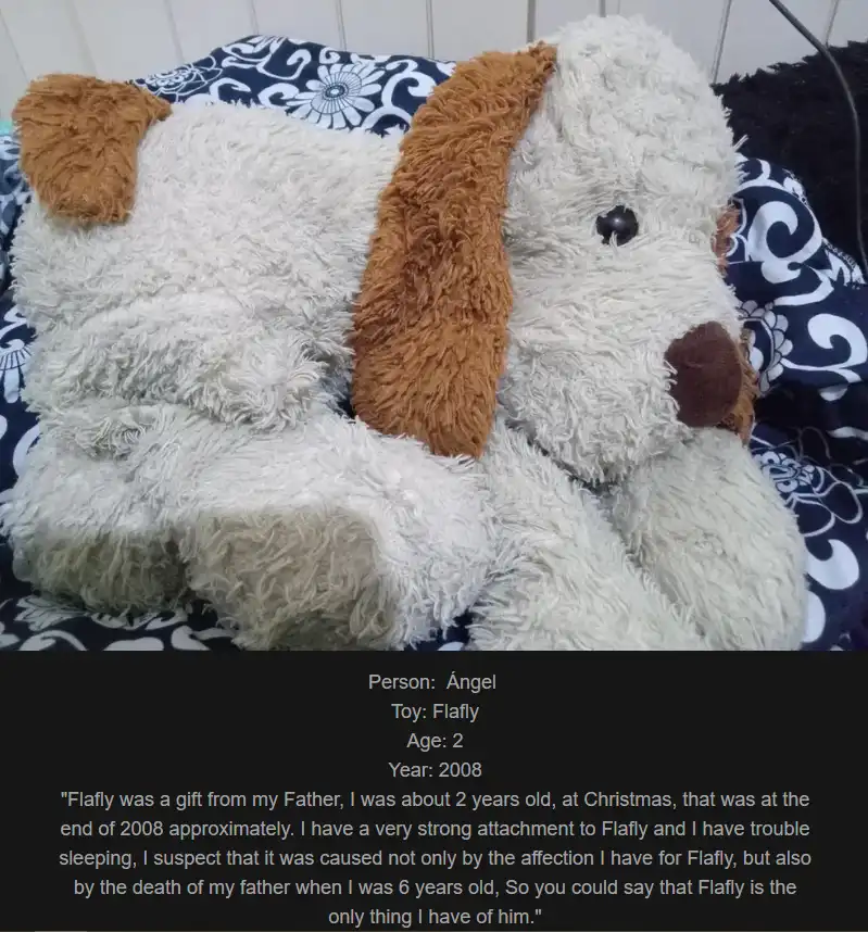 A fluffy white stuffed dog toy with brown ears and nose rests on a blue and white patterned blanket. Overlaid text…