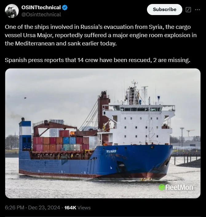 A blue cargo ship named 'URSA MAJOR' is shown sailing on water, loaded with colorful shipping containers. The overlaid text…