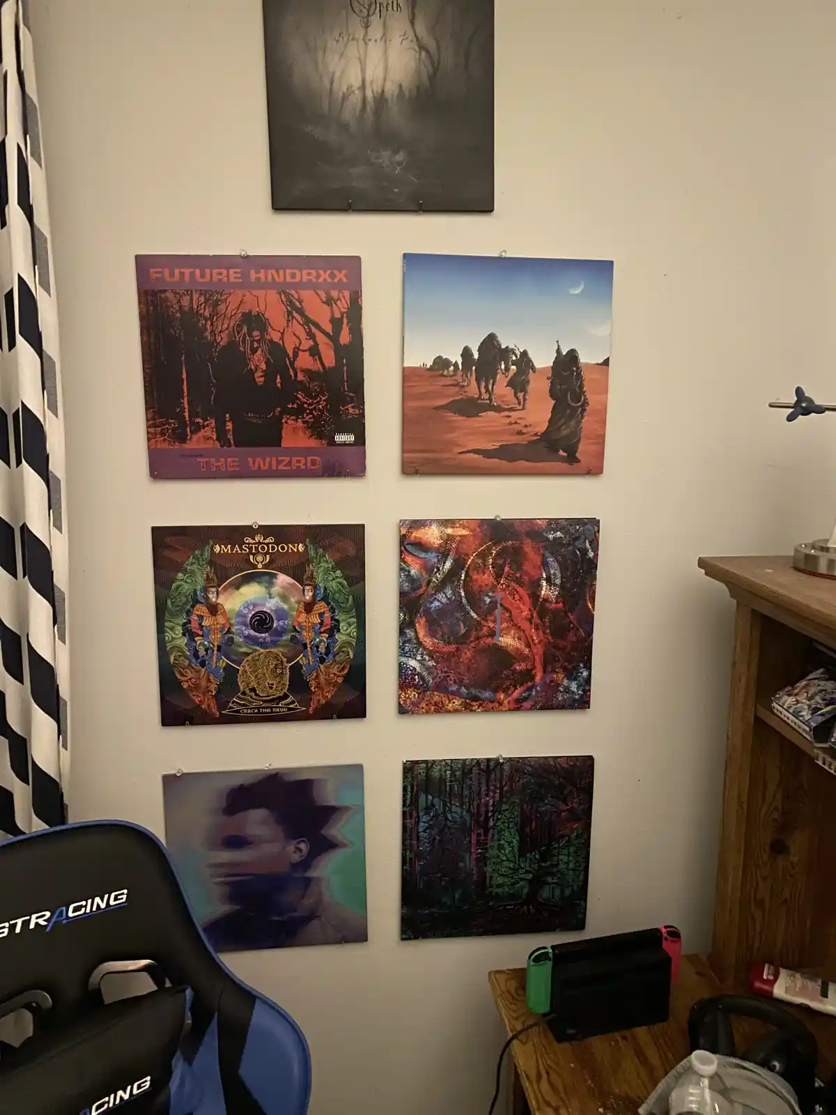 A wall displays seven framed album covers, including Future Hendrix, Mastodon, and Opeth, arranged in a grid. A blue gaming…