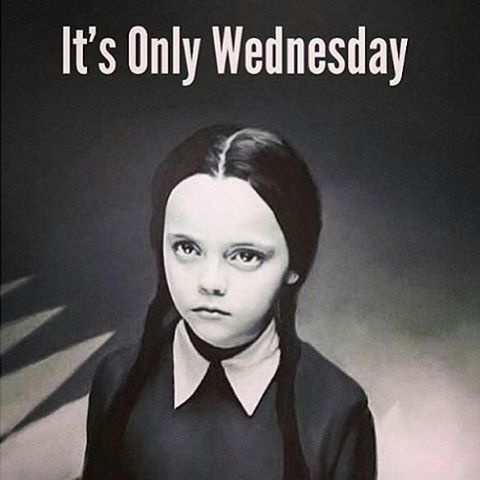 A black-and-white image of Wednesday Addams from the Addams Family, looking directly at the camera with a serious…