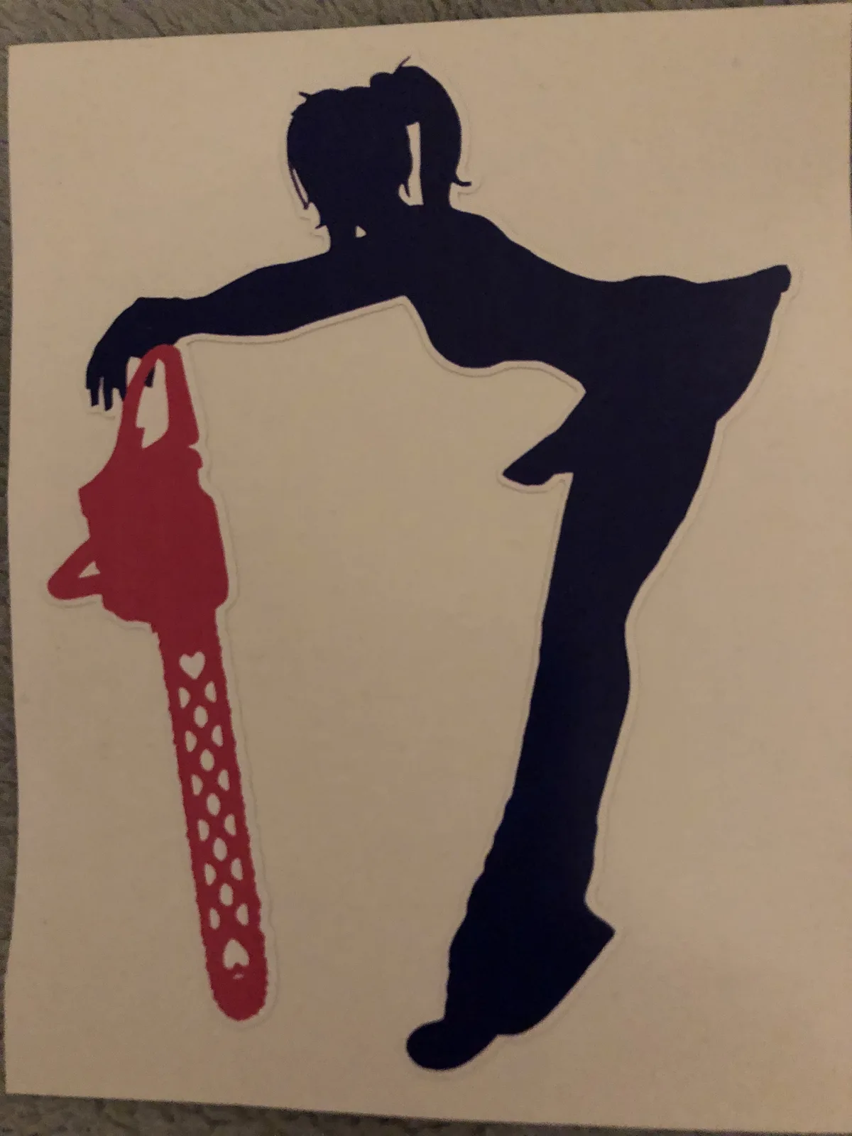 A black silhouette of a person with pigtails, posed in a dynamic stance, holds a red chainsaw decorated with heart shapes…